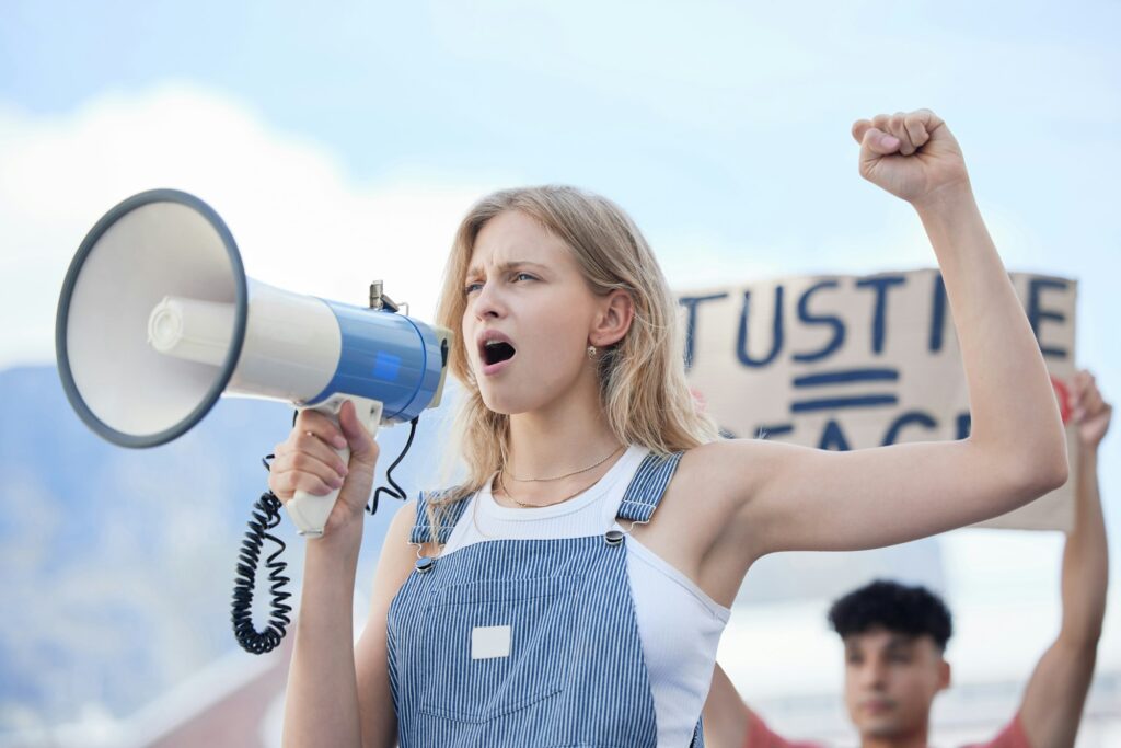 Justice, megaphone and woman protest for justice, community solidarity and human rights voice on ra